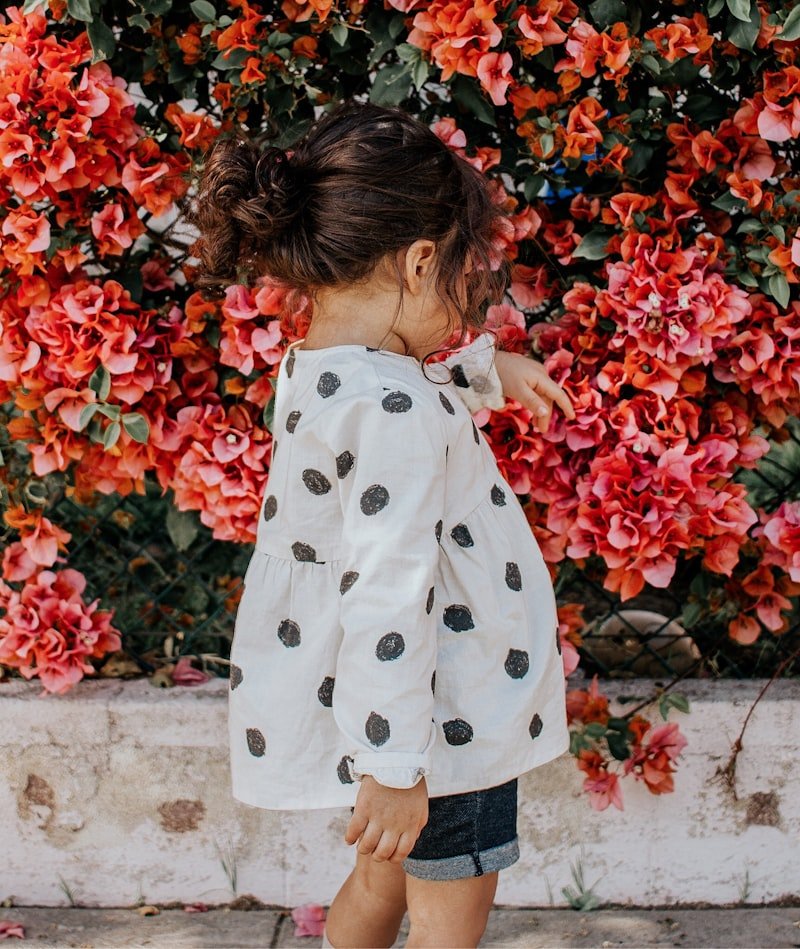enfant portant la marque etikashion dans un champ de fleur